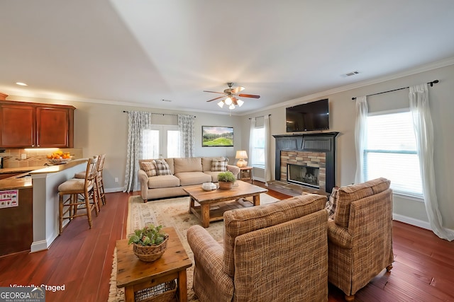 living room with visible vents, dark wood-type flooring, and ornamental molding