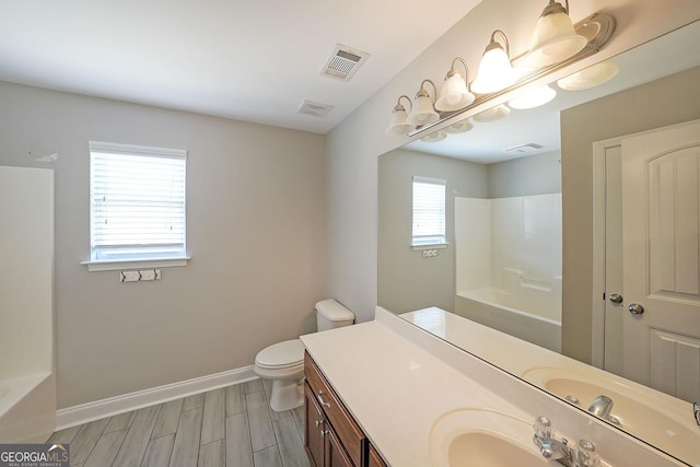 bathroom featuring wood finish floors, visible vents, toilet, vanity, and baseboards