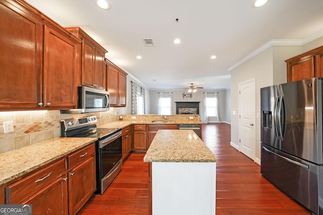 kitchen with ornamental molding, appliances with stainless steel finishes, visible vents, and tasteful backsplash