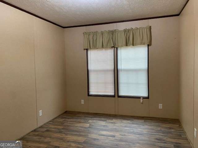 spare room featuring a textured ceiling, crown molding, and dark hardwood / wood-style floors