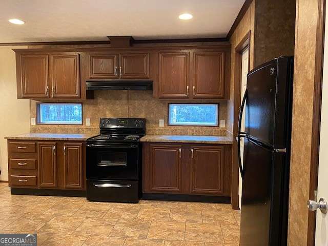 kitchen with light stone countertops, decorative backsplash, and black appliances