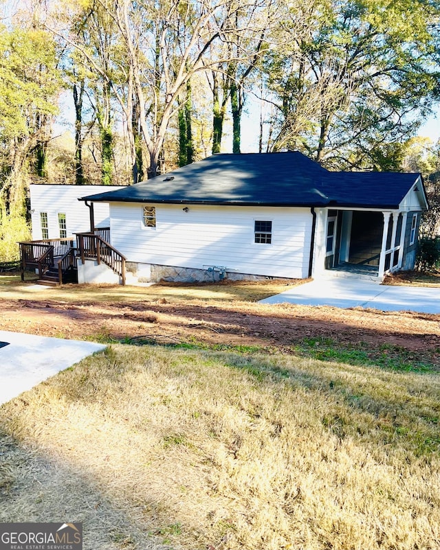 view of property exterior featuring a yard and a carport