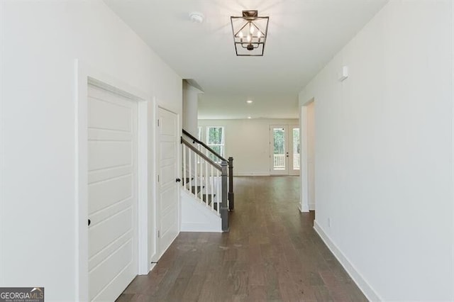 corridor with a chandelier, french doors, and dark hardwood / wood-style floors