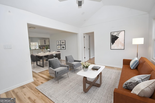 living room featuring light wood-type flooring, vaulted ceiling, and ceiling fan