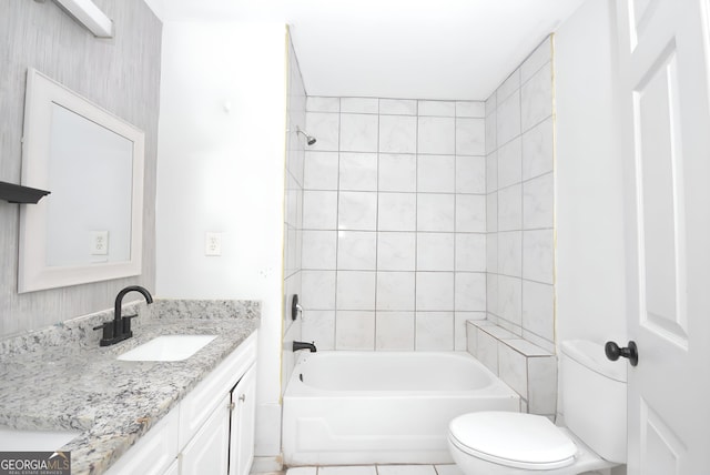 full bathroom with vanity, tiled shower / bath combo, and toilet