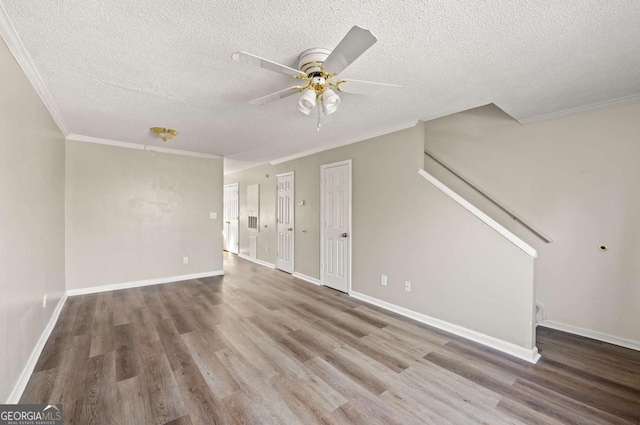 unfurnished living room featuring crown molding, ceiling fan, a textured ceiling, and hardwood / wood-style flooring