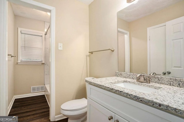 bathroom with vanity, toilet, wood-type flooring, and a textured ceiling