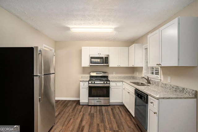 kitchen featuring a textured ceiling, stainless steel appliances, dark wood-type flooring, sink, and white cabinetry