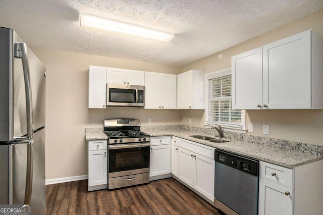 kitchen with dark hardwood / wood-style flooring, white cabinetry, sink, and stainless steel appliances