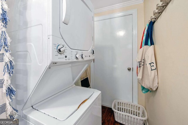 washroom with dark hardwood / wood-style flooring, stacked washer / drying machine, and ornamental molding