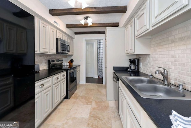 kitchen featuring beamed ceiling, appliances with stainless steel finishes, white cabinets, and sink