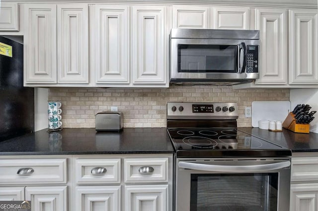 kitchen featuring white cabinets, appliances with stainless steel finishes, and backsplash