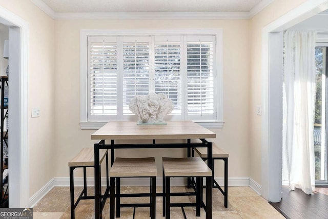 dining room with crown molding, plenty of natural light, and light hardwood / wood-style floors