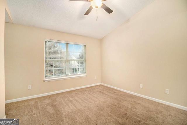 spare room featuring a textured ceiling, ceiling fan, carpet floors, and lofted ceiling