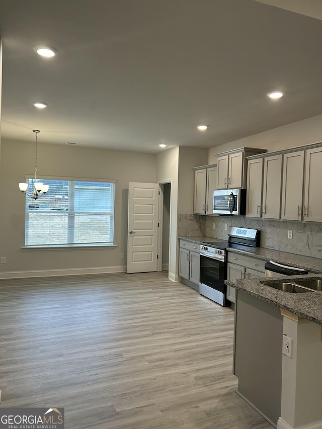 kitchen featuring light hardwood / wood-style floors, stainless steel appliances, decorative light fixtures, a chandelier, and gray cabinets