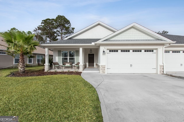 view of front of home with a front lawn, covered porch, and a garage