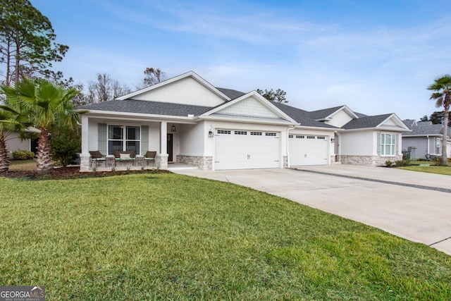 view of front of home featuring covered porch, a garage, and a front yard