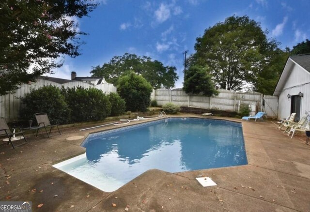 view of swimming pool with a patio, a diving board, a fenced backyard, and a fenced in pool