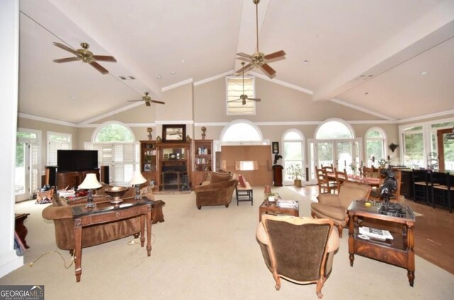 carpeted living area with plenty of natural light, a ceiling fan, and crown molding