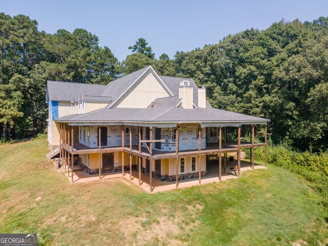 rear view of property featuring a yard and a patio