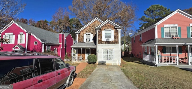 view of property featuring a sunroom and a front lawn