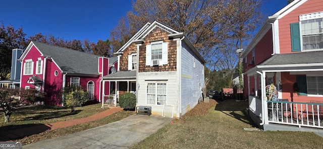 view of front facade with a front yard and cooling unit