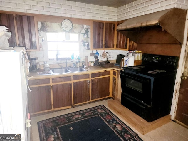 kitchen featuring black electric range oven, exhaust hood, sink, light tile patterned floors, and white fridge