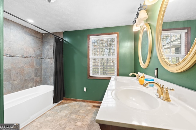 bathroom with shower / bathtub combination with curtain, a textured ceiling, baseboards, and a sink