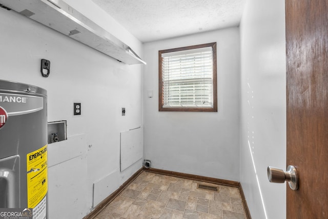 clothes washing area with electric dryer hookup, visible vents, a textured ceiling, water heater, and laundry area