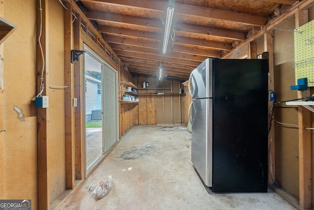 interior space featuring concrete floors and freestanding refrigerator