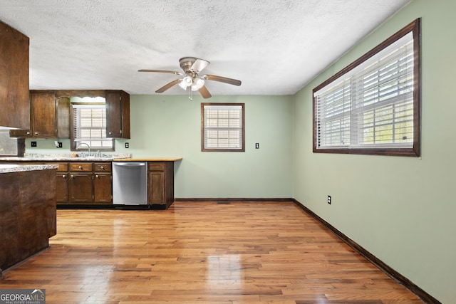 kitchen with light wood finished floors, a sink, light countertops, dark brown cabinets, and dishwasher