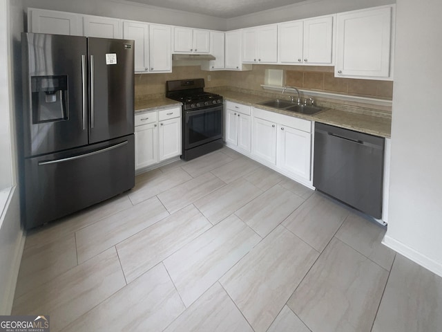 kitchen featuring sink, light stone countertops, appliances with stainless steel finishes, tasteful backsplash, and white cabinetry