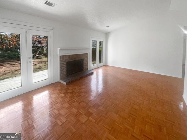 unfurnished living room with a wealth of natural light, french doors, and parquet floors