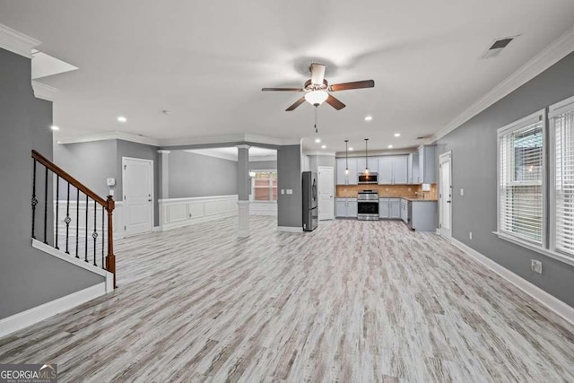 unfurnished living room featuring plenty of natural light, light wood-type flooring, and ornamental molding