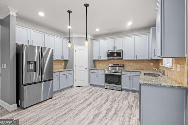 kitchen with sink, light hardwood / wood-style floors, decorative light fixtures, gray cabinets, and appliances with stainless steel finishes