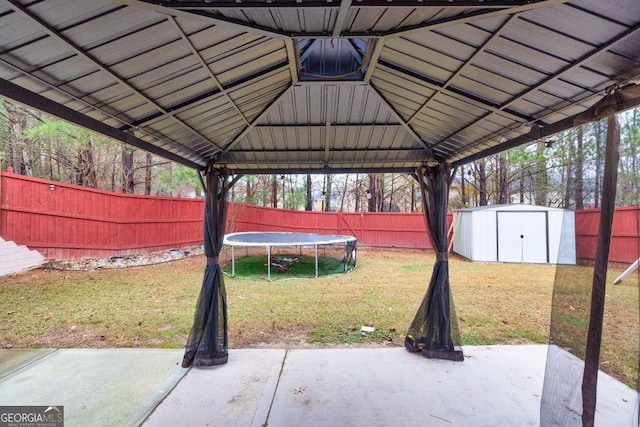 view of patio featuring a gazebo, a trampoline, and a shed