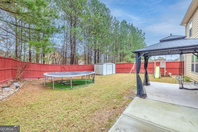 view of yard featuring a gazebo, a shed, a trampoline, and a patio