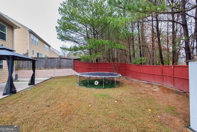 view of yard featuring a gazebo, a trampoline, and a patio