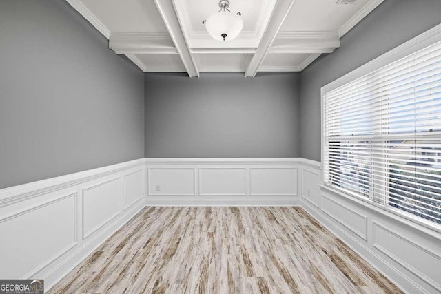 unfurnished room with beam ceiling, light hardwood / wood-style flooring, ornamental molding, and coffered ceiling