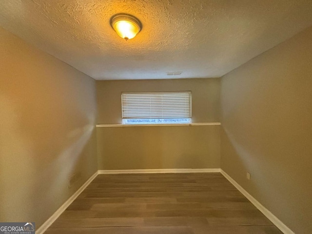 unfurnished room featuring a textured ceiling and hardwood / wood-style flooring