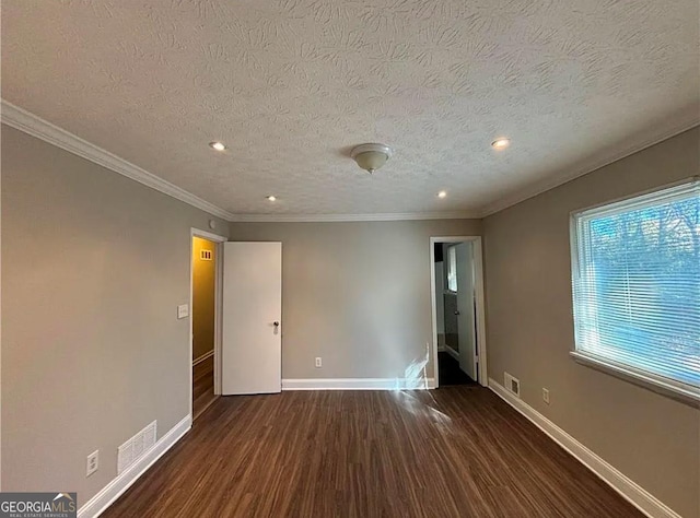 spare room with a textured ceiling, dark hardwood / wood-style flooring, and ornamental molding