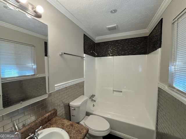 full bathroom featuring toilet, crown molding, tile walls, a textured ceiling, and shower / bathtub combination