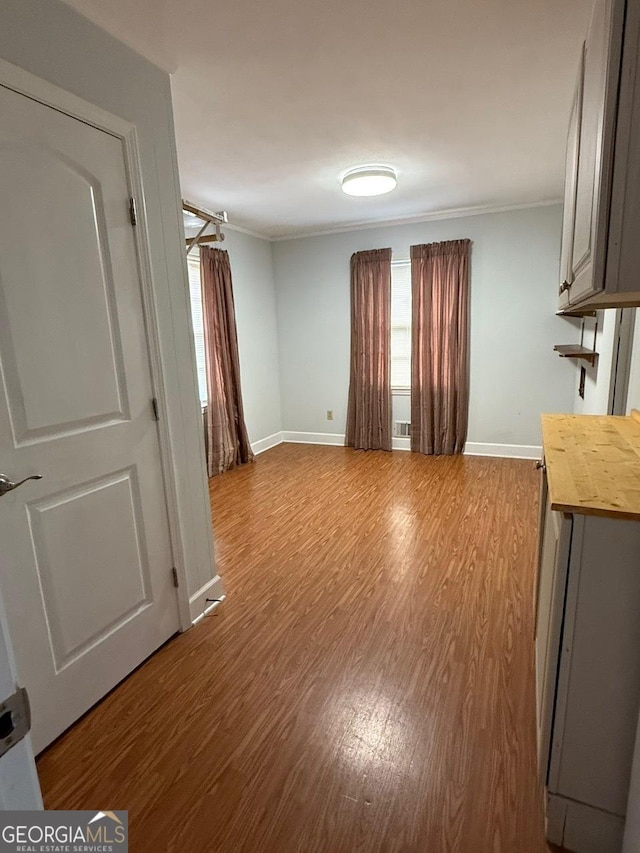 interior space with crown molding and light hardwood / wood-style flooring