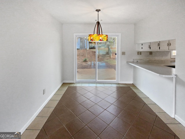 unfurnished dining area featuring dark tile patterned floors