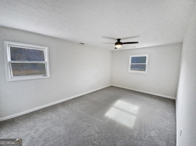 carpeted empty room featuring ceiling fan and a textured ceiling