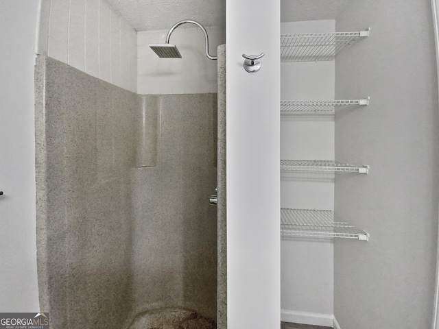 bathroom featuring a shower and a textured ceiling