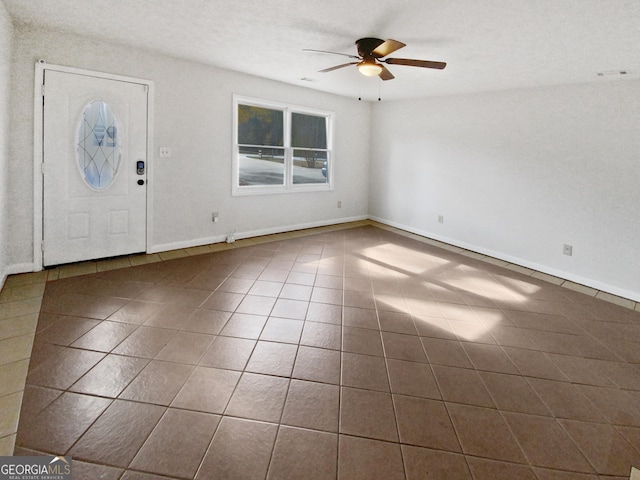 tiled entrance foyer featuring ceiling fan and a textured ceiling