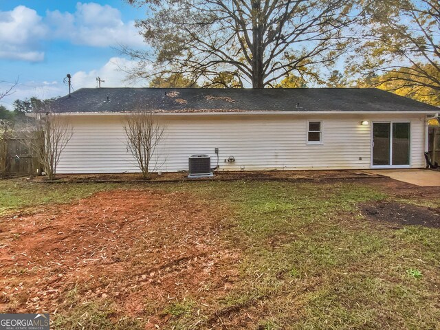 rear view of property with a lawn and central AC unit