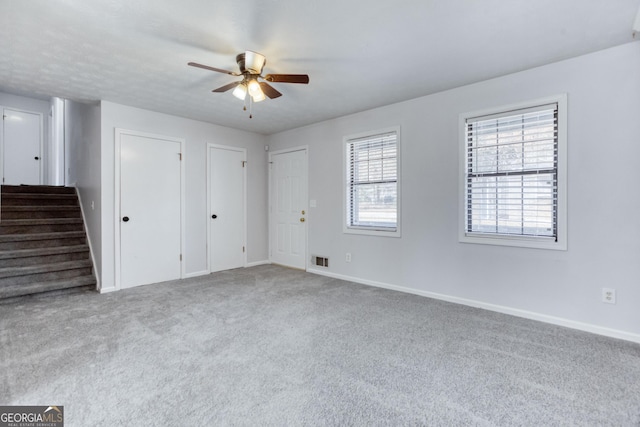 carpeted spare room with ceiling fan