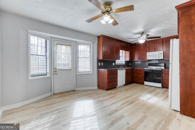 kitchen featuring ceiling fan, white appliances, backsplash, and light hardwood / wood-style flooring